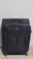 Full frontal view of the black Samsonite soft suitcase showing the front zippered pocket and handle.