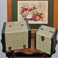 Two vintage fabric/faux leather cases, one larger and one smaller, both with metal clasps and carrying handles.