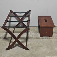 Wooden collapsible luggage rack and wooden stool side by side on floor.
