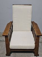 Front view of the vintage wood recliner chair showing cream cushion on seat and backrest.