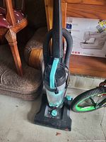 Front view of Bissell upright vacuum cleaner showing handle, dirt container, and base.
