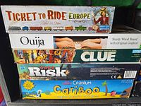 Stacked boxes of five board games from the lot, showing titles and partial artwork on each box.