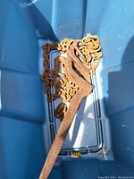 Metal chain with attached large rusted industrial hook inside a blue container