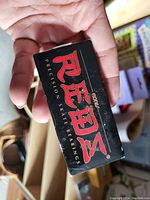 Photo of a black box with the Bones logo containing precision skate bearings held in a person's hand.