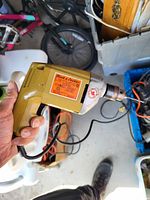 Hand-held view of a Yellow Black & Decker electric drill model #8 with visible label and power cord.