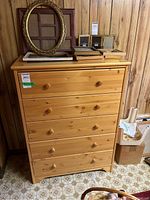 Front view of the pine wood dresser showing five drawers with wood knobs.