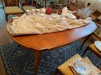 Top and side view of wood dining table with beveled top and leaf extension, showing polished reddish-brown finish and slender legs.