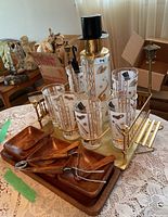 Full view of vintage seltzer bottle, six matching glasses in metal caddy, and wood condiment set with tray.