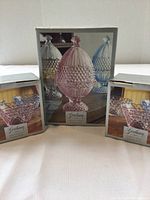Three boxes of Gorham Emily's Attic collection: One large lidded candy dish box in pink and two smaller votive candle holder boxes.