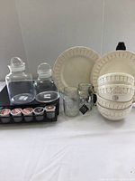 Overall kitchen items including Keurig pod holder, white plates, bowls, and glass jars arranged together