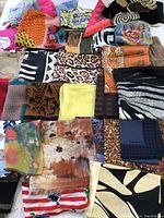 Top view showing a variety of scarves in different colors and patterns, including floral, animal prints, geometric, and solid colors