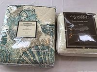 Northshore Linens twin quilt in sealed packaging with blue and beige seashell pattern and Cozelle down alternative throw in sealed packaging