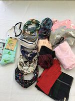 Full lot showing socks, headbands, scarves, satin pillowcase, gloves, and pouches arranged on a white surface