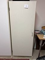 Closed white laminate cupboard, full height, single door with handle