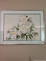 Full view of the framed watercolour painting showing white flowers and green leaves with a silver frame and green matting border