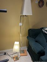 Photo showing both the tall floor lamp and smaller table lamp together, with tags indicating lot number.