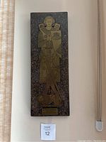 Full view of rectangular medieval style wall art plaque with knight etched in brass on stone background