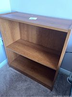 Side view of wood look laminate bookshelf showing adjustable shelf and wood grain finish.