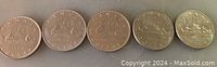 Photo of five Canadian $5 coins from 1968, 1969, 1972, 1975, and 1978, showing their reverse sides with canoe imagery.