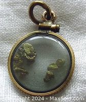 Close-up front view of the gold filled round charm showing natural gold flakes inside glass.