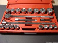 Open red plastic case displaying 21 piece socket set including ratchet, extension bars, and sockets arranged by size.