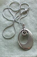 View of the pendant and attached chain showing overall design and condition