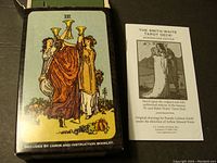 Photo showing three robed women holding cups card from the deck and the box with text showing the deck contains 84 cards and an instruction booklet.