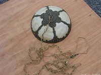 Top view of the circular slag glass lamp with ornate metal framework and hanging chain.