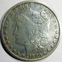 Obverse side of 1880 Morgan silver dollar showing Lady Liberty profile, inscriptions, date, and stars.