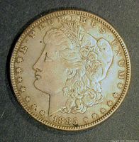 Obverse side of the 1885 Morgan Silver Dollar, showing Lady Liberty profile, date, and inscription with some wear visible.