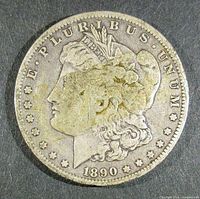 Obverse side of 1890-O Morgan silver dollar showing Lady Liberty profile.