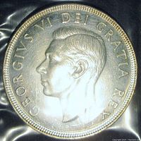 Obverse side of 1951 Canadian silver dollar coin showing King George VI portrait with legends.