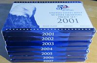 Stack of seven US Mint 50 State Quarters Proof Sets in original boxes from 2001 to 2007 with eagle design and state names listed.