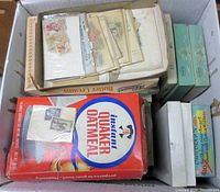 Photo showing box with envelopes containing stamps and small boxes with foreign stamps sorted by country