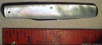 Top view of the closed pocket cutting tool with mother-of-pearl handle and measuring ruler showing about 3 inches long.