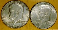 Obverse side of two 1964 Kennedy half dollars showing profile of John F. Kennedy with inscriptions and date.