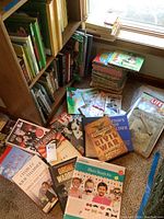 Wide view of various books and magazines on floor including history, photography, and children's books