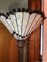 Closer view of the stained glass style lampshade showing white and beige glass panels with dark border and dark bead embellishments on top edge.