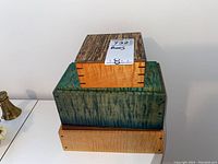 Three wooden decorative boxes stacked on each other showing size and wood grain differences