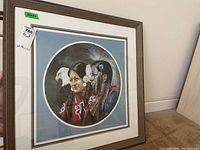 Framed circular print showing two Native American figures wearing traditional clothing and one eagle, signed and numbered by the artist.