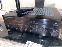 Yamaha RX-596 stereo receiver with various knobs and preset buttons, black finish.