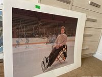 Full view of unframed hockey print leaning against wall