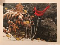 Print showing a red cardinal bird perched among orange ferns and snow on ground