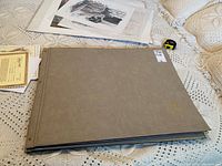Grey folder with gold 'Endangered Species' embossed lettering, closed on a crocheted blanket.