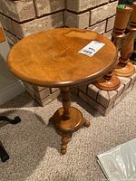 Photo of the round wooden tabletop showing surface wear including water stains and scratches