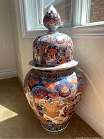Full view of large Asian style temple jar with lid showing shape and colorful detailed decorations including dragons and floral patterns.