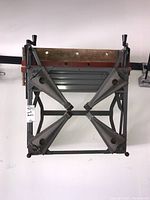 Top-down and angled views of the metal folding workbench showing the articulated metal legs and wooden top edge.