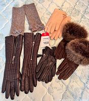 Photo showing the assortment of six pairs of ladies gloves laid out to view variations in material and style.