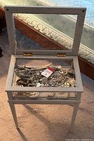 White painted wood display case with glass top opened to show interior and jewelry