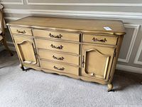 Wooden mid century buffet sideboard showing front view with drawers, cabinet doors, and decorative handles.